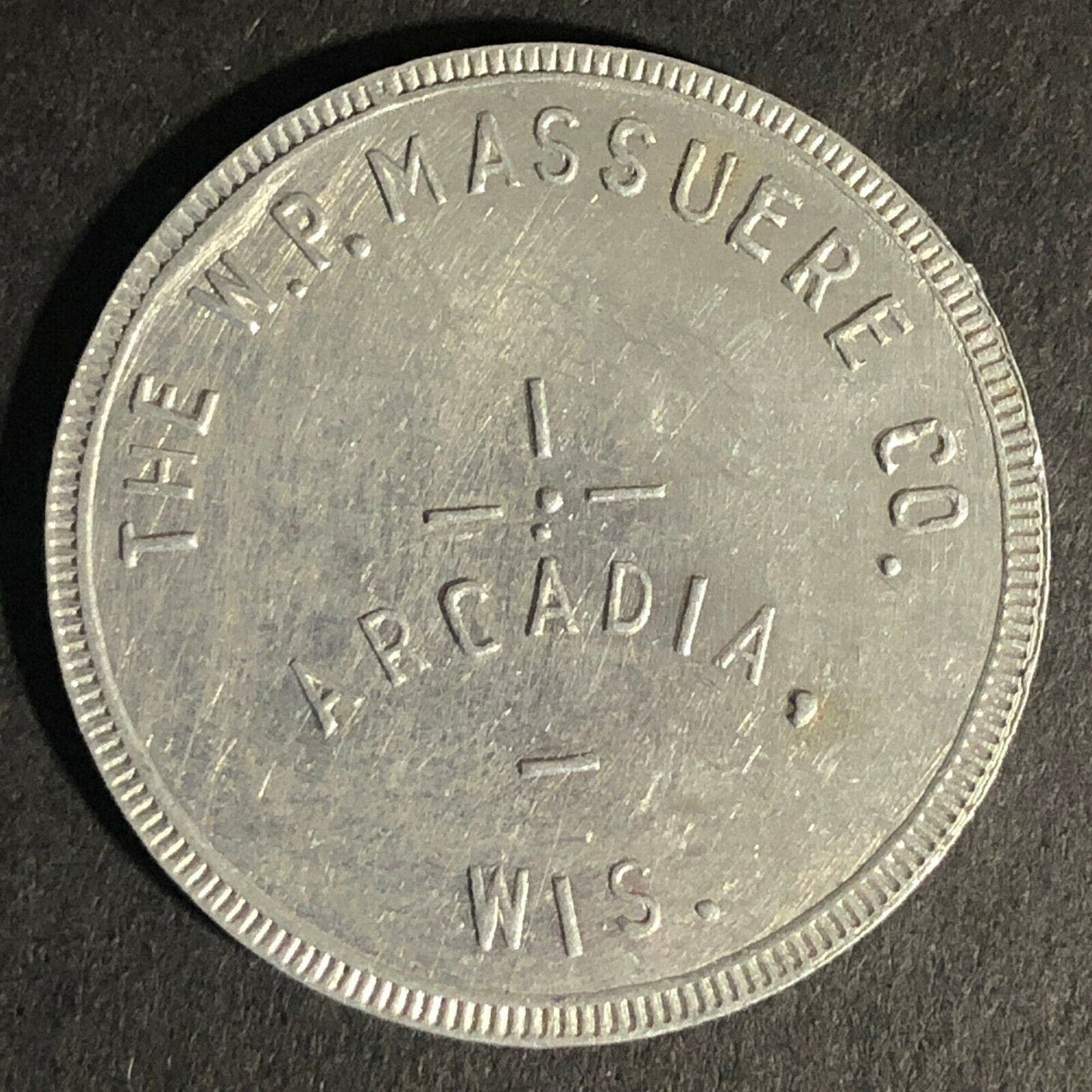 The W.P. Massuere Co. Arcadia, WI Alum. Token G/F $1 in Merchandise 31mm